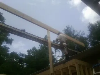 Carpenter setting a ridge beam over a new addition frame — Ice Dam Removal by Roofing Brothers in Molalla
