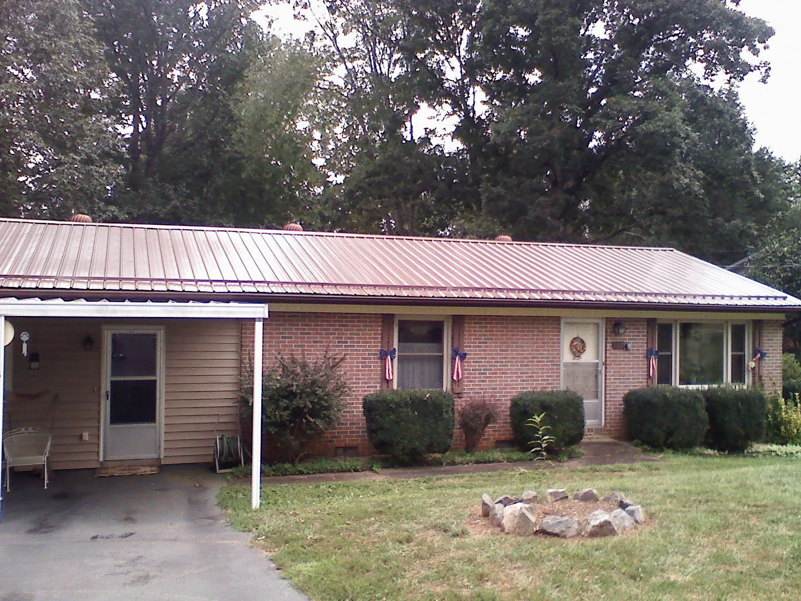 Bronze metal roof and carport on a brick ranch home — Roof Repair work by our crew in Molalla
